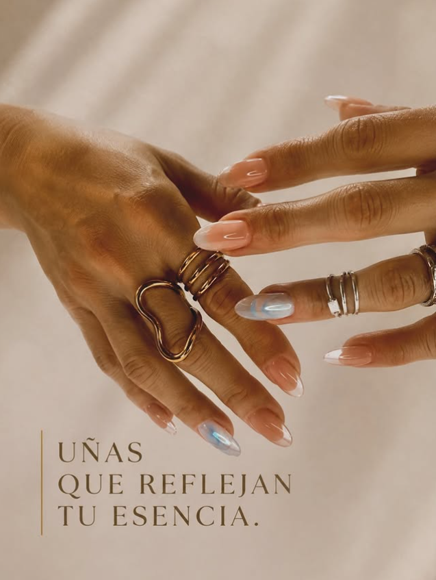 Manos con uñas almendradas en tonos nude y anillos dorados