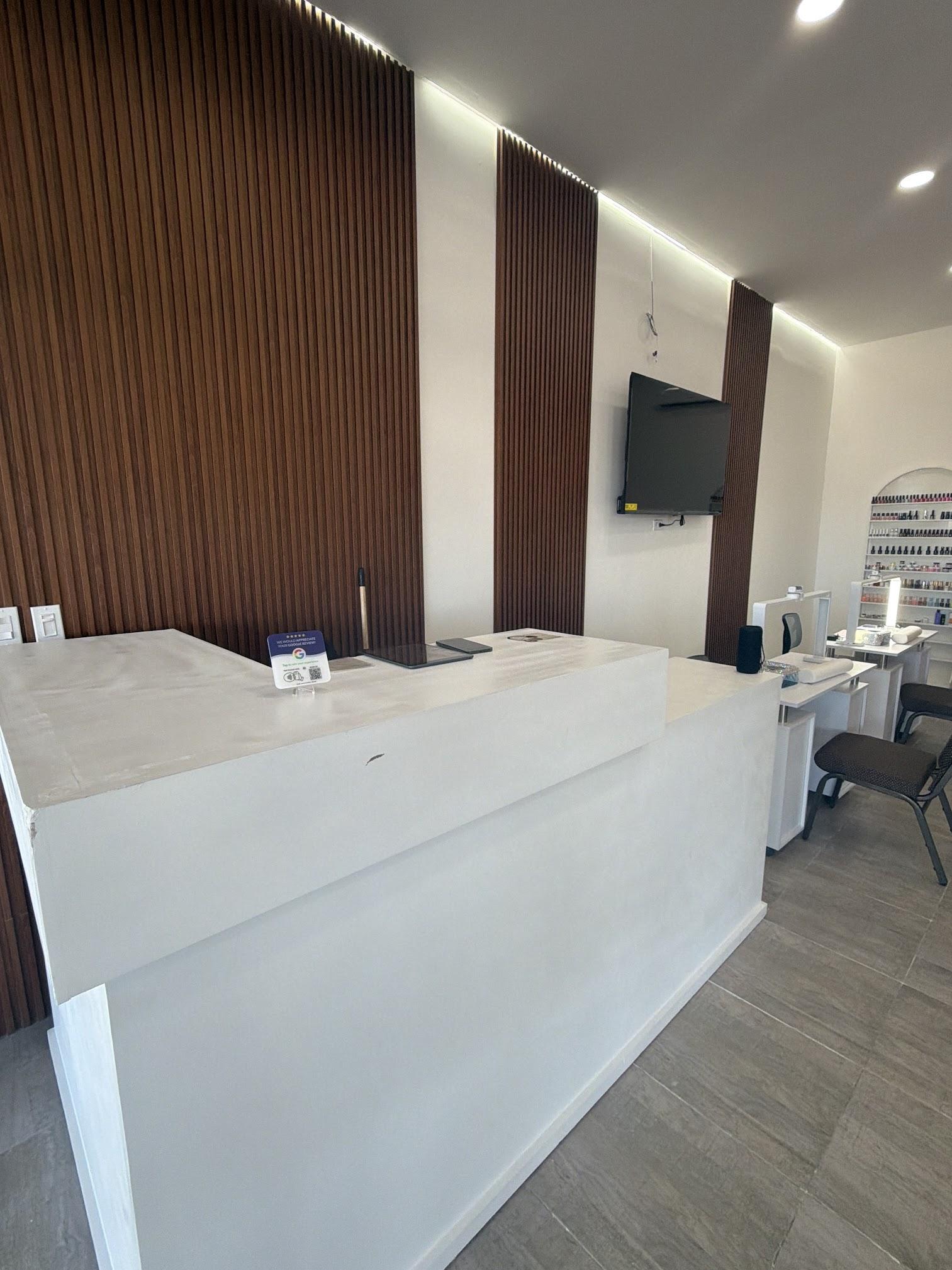 Recepción de MG Glamor Nails con muro de listones de madera y mostrador blanco